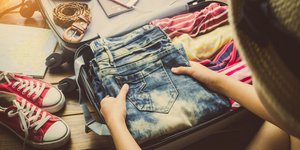 Γυναίκα βάζει ρούχα σε βαλίτσα