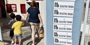 Μια μητέρα μπαίνει με τα δυο παιδιά της στο εκλογικό της τμήμα