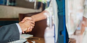 Γυναίκα δίνει το χέρι της σε άνδρα με κοστούμι