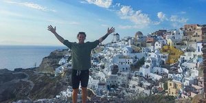 Αυστραλός τουρίστας ποζάρει με φόντο την Οία της Σαντορίνης