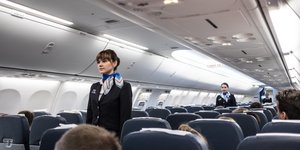 Τρεις αεροσυνοδοί μέσα στο αεροπλάνο με σκούρα ρούχα