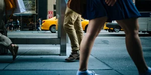 Μια γυναίκα με μίνι μπλε φούστα κι ένας άνδρας με χακί παντελόνι στο δρόμο