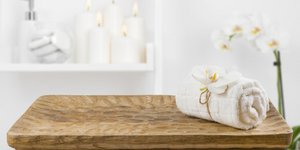 Ξύλινο τραπέζι με λευκή πετσέτα τυλιγμένη και ορχιδέα