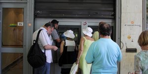 Κόσμος περιμένει στην ουρά για τη θέση του σε ΑΤΜ