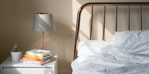 Κρεβάτι και κομοδίνο σε κρεβατοκάμαρα διαμερίσματος 