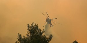 Ελικόπτερο της πυροσβεστικής πραγματοποιεί ρίψη νερού στη φωτιά στην Εύβοια