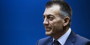 Ο Γιάννης Βρούτσης σε μπλε φόντο