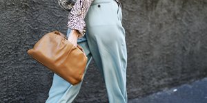 Γυναίκα με γαλάζιο παντελόνι και τσάντα