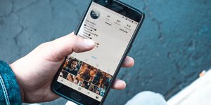 Instagram λογαριασμός σε κινητό τηλέφωνο που κρατά άνδρας
