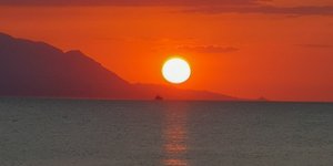 Ο ήλιος δύει στη θάλασσα σε κάποιο μέρος της Ελλάδας