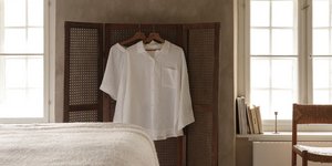 Kρεβατοκάμαρα με κρεβάτι, καρέκλα, ένα πουκάμισο και ένα T-Shirt κρεμασμένα