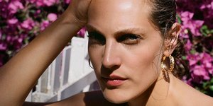 Moντέλο ποζάρει στον φακό και φορά χρυσούς κρίκους