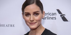 H Oλίβια Παλέρμο με μαύρο κοστούμι χαμογελά