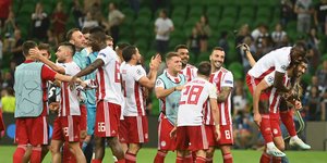 Παίκτες του Ολυμπιακού πανηγυρίζουν στο χορτάρι
