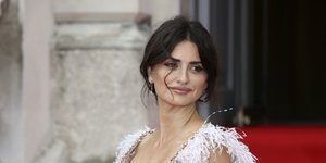 Η Πενέλοπε Κρουζ χαμογελάει με λευκά φτερά στα μανίκια