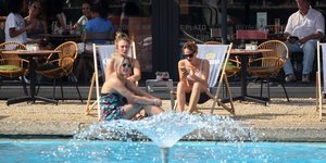 Κόσμος σε μαγαζί μπροστά σε συντριβάνι