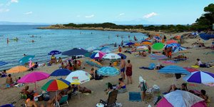 Ομπρέλες και κόσμος σε παραλία