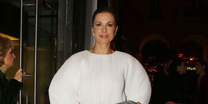 Η Τζίνα Αλιμόνου με λευκή μπλούζα με φουσκωτά μανίκια και μαύρο παντελόνι