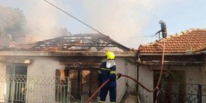 Πυροσβέστης σβήνει φωτιά σε σπίτι