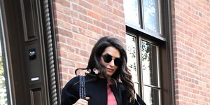 Η Αμάλ Αλαμουντίν με μαύρη μίνι φούστα, μαύρες μπότες και μαύρο τζακετ