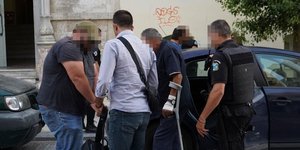 Κατηγορούμενοι μπαίνουν σε αυτοκίνητο της ασφάλειας