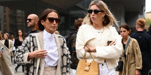 Δύο γυναίκες με γυαλιά και τσάντες περπατούν στο δρόμο