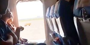 Οι επιβάτες κάθονται πλάι στην ανοιχτή έξοδο κινδύνου του αεροσκάφους