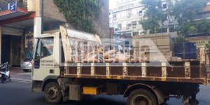 Φορτηγό του Δήμου Αθηναίων μεταφέρει οικοδομικά υλικά για να σφραγιστούν τα κτίρια 