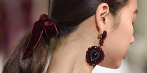 Γυναίκα με φιόγκο στα μαλλιά και σκουλαρίκια