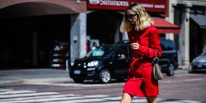 Ξανθιά γυναίκα με κόκκινο φόρεμα και τσάντα 