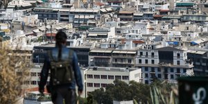 Κοπέλα κοιτά από ψηλά σπίτια στην Αθήνα