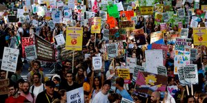 Πλήθος κόσμου με πλακάτ στη Βρετανία διαδηλώνει για την κλιματική αλλαγή