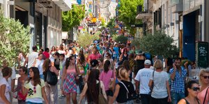 Κόσμος περπατά σε δρόμο με μαγαζιά