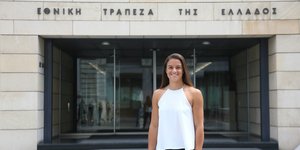 Η Μαρία Σάκκαρη μπροστά στο κτίριο της εθνικής Τράπεζας