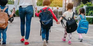 Μητέρα με παιδιά με σχολικές τσάντες