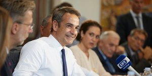 Ο Κυριάκος Μητσοτάκης μιλάει χαμογελαστός σε μικρόφωνο