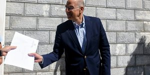 Νίκος Δένδιας ορθιος δινει χαρτι
