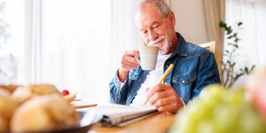 παππούς λύνει σταυρόλεξο με καφε 
