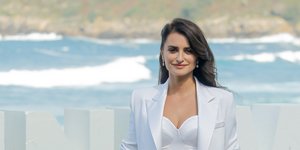 Η Πενέλοπε Κρουζ με λευκό κοστούμι χαμογελά