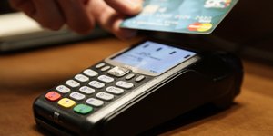 Μηχάνημα POS και ένα χέρι που κρατά μια κάρτα