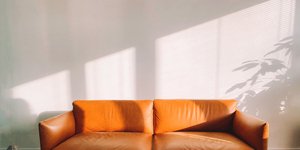 Kαθιστικό διαμερίσματος με λευκούς τοίχους και δερμάτινο καναπέ