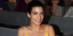 Η Τόνια Σωτηροπούλου με κίτρινο φόρεμα καθισμένη 