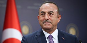 Ο Μεβλούτ Τσαβούσογλου και πίσω η τουρκική σημαία