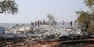 Άνθρωποι στα ερείπια του κρησφύγετου του νεκρού αρχηγού του ISIS, αλ Μπαγκντάντι, στη βορειδυτική Συρία