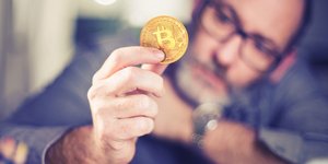 άντρας κρατάει Bitcoin