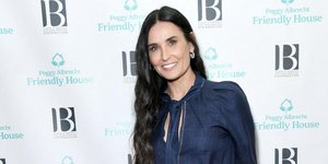 η Ντέμι Μουρ χαμογελά με μπλε φόρμα και σκουλαρίκια