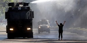 Διαδηλωτής βρέχεται από μάνικα με νερό στη Χιλή