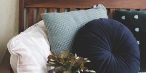 μαξιλαρια σε ξυλινο καναπε και φυτο