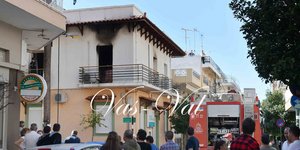 Πυροσβεστικό όχημα και κόσμος έξω από σπίτι που έπιασε φωτιά