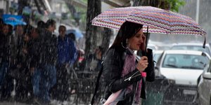 Γυναίκα κρατάει ομπρέλα στη βροχή
